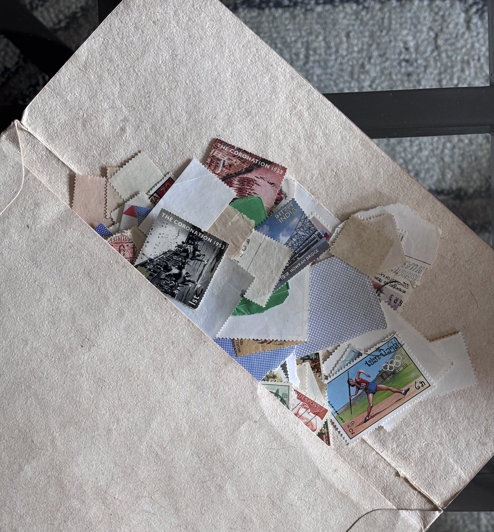The old white envelope, open, stamps spilling out of it