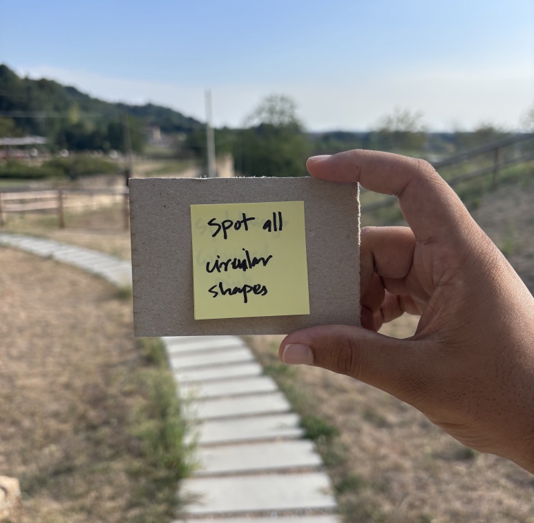 A hand holding a card with a sticky note that says spot all window shapes